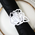 Gros plan d'un rond de serviette en papier nacré blanc avec fleur de rose découpée - Blanc