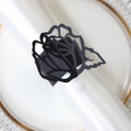Detail of laser-cut black rose paper napkin ring with elegant floral hollow pattern - Black