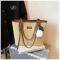 Detail of straw woven tote with brown leather handles and a decorative tassel on a suitcase - Khaki