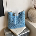 Hellblaue geflochtene Tragetasche mit Lederriemen auf Vintage-Koffer - Blau