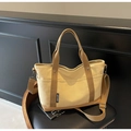 Detail of beige canvas tote with brown straps and detachable shoulder belt on a chair - Khaki