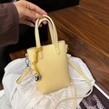 Pale yellow crossbody handbag with litchi grain texture and heart pendant charm - Yellow