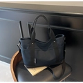 Detail of a black canvas tote bag with adjustable strap and multiple pockets on a chair - Blue