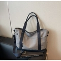 Detail of gray canvas tote bag with navy blue side pocket and adjustable shoulder strap - Gray