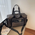Large dark charcoal travel bag with wide shoulder strap in a minimalist setting - Gray