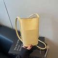 Lichtgele crossbody telefoontas van kiezelleder met voorvak en trendy emmerontwerp - Geel