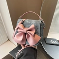 Grey denim saddle bag featuring a large pink leather bow and adjustable strap - Blue