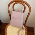 Bolso de moda rosa pálido con textura fina y herrajes metálicos plateados en silla de madera - Rosa