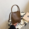 Dark brown leather bucket bag with pebble grain texture and adjustable long strap - Brown