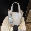 Chic cream white bucket bag with top handle, silver hardware and a matching lock charm - Gray