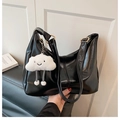 Detail view of glossy black PU leather tote bag featuring a cute white cloud plush pendant - Black with Pendant