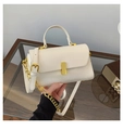 Close-up of a cream crossbody bag featuring a gold square buckle and leather chain strap - Beige