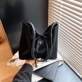 Black glossy tote bag featuring a large decorative bow and metallic sphere accents - Black