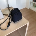 Minimalist black shell crossbody phone bag with woven shoulder strap on a wooden desk - Black (Without Pendant)