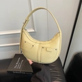 Pale yellow crescent-shaped underarm bag featuring lychee texture and front flap pockets - Yellow