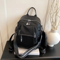 Black pebbled faux leather backpack with a detachable black and white arrow pattern strap - Black