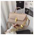 Detail of beige square bag showing gold turn-lock, chain decor, and smooth leather texture - Khaki