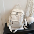 White litchi pattern backpack with silver zippers and a matching mini round pouch charm - White