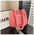 Primer plano de bolso de punto suave en rosa vibrante con etiqueta de logo de moda - Rosa