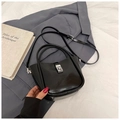 Chic black glossy bucket bag with silver clasp on office suit background - Black