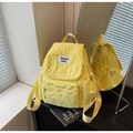 Detail of yellow nylon backpack featuring drawstring pockets and woven brand label - Yellow