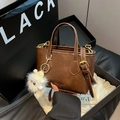 Dark brown leather bucket bag with gold hardware and white plush monster charm - Brown with Pendant