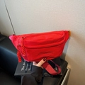Red canvas casual waist bag with double zipper and adjustable strap in hand display - Burgundy