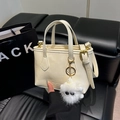 Chic cream white bucket bag with dual handles and a cute plush monster charm detail - White with Pendant
