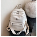 Detail view of cream-white PU leather backpack with geometric pattern woven straps - White