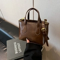 Sac seau élégant en cuir brillant marron foncé avec poignées et détails dorés - Brun Sans Pendentif