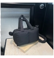 Detail der schwarzen gesteppten Puffer-Tasche mit dicken Grifen auf Marmoroberfläche - Schwarz