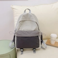 Detail view of the tricolor gray nylon backpack featuring front zip pocket and side pockets - Gray