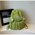 Detail shot of the green nylon backpack featuring white buckle closure and drawstring opening - Green