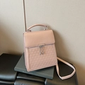 Pink faux leather handbag with quilted texture and silver chain detail on green book - Pink