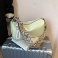 Mint green shoulder bag with geometric woven strap and silver logo on a suitcase - Green