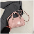 Chic pink bowling bag with embossed logo and adjustable strap in lifestyle setting - Pink Without Pendant