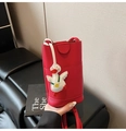 Dettaglio della borsa a tracolla rossa con trama a litchi e ciondolo a forma di papera - Con Ciondolo / Rosso
