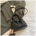 Detailsicht auf schwarze Webstruktur und glatten Lederriemen einer Beuteltasche - Schwarz