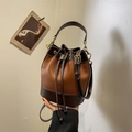 Bolso saco bicolor en caramelo y marrón con cordón y correa ajustable de - Marrón café