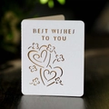 Détail d'une carte de vœux blanche découpée au laser avec motifs cœurs sur bois - Blanc