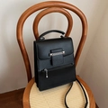 Elegante schwarze minimalistische Handtasche mit Silberkette auf einem Vintage-Stuhl - Schwarz