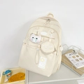Detail view of cream student backpack with star patches and cute plush cat keychain charm - With Charm / Off White
