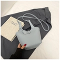 Chic light blue lychee pattern bucket bag with knot strap on a grey blazer background - No Pendant / Blue