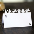 White laser cut Christmas place card with snowman and reindeer on wood table - White