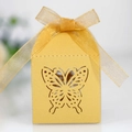 Detail des lasergeschnittenen Schmetterlingsmusters auf gelber Geschenkbox mit Schleife - Gold