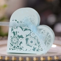 Close-up of light blue laser-cut heart favor box with butterfly pattern and ribbon - Pearl Pale Blue