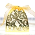 Macro detail of gold laser-cut butterfly wedding favor box with a silk ribbon bow - Reflective Gold