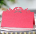 Macro shot of laser-cut red place cards with heart and bird motifs for weddings - Pearlescent Red