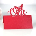 Macro view of a red glitter table card with laser-cut butterfly and One text - Pearlescent Red