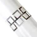 Detailed close-up of a silver hollow geometric napkin ring on a white silk napkin - Silver